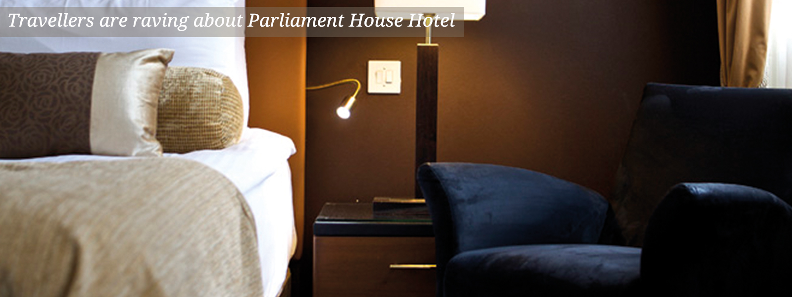 Bed, bedside table and chair at The Parliament House Hotel