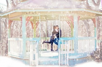 Couple kissing in a gazebo in the snow