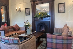 Tartan chairs around the fireplace in the lounge