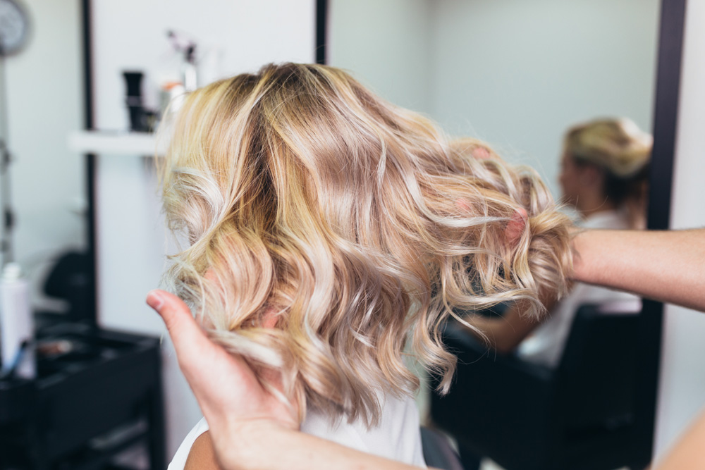 Lady with blonde waves having hair done in a salon