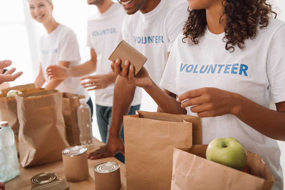 Volunteers putting food into bags to help a charity