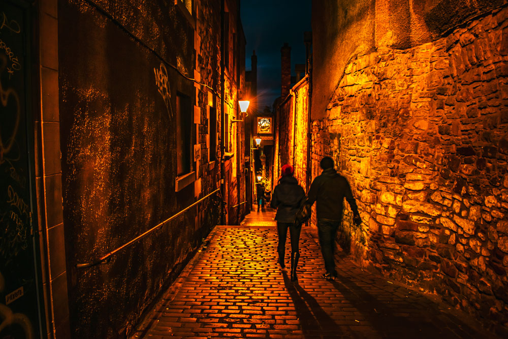 A couple walking through a narrow close in Edinburgh