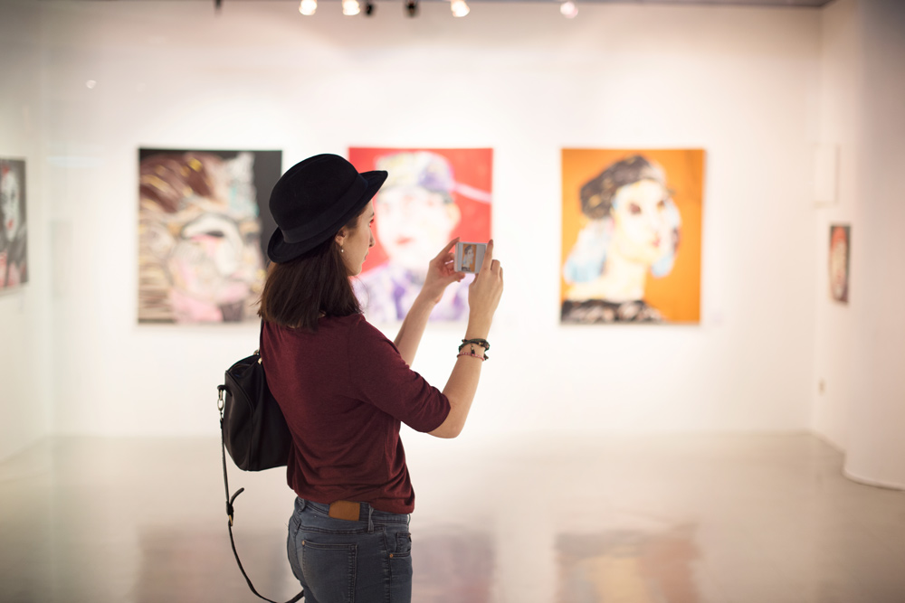 Woman taking photos in an art gallery