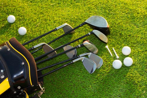 Golf clubs and equipment on grass