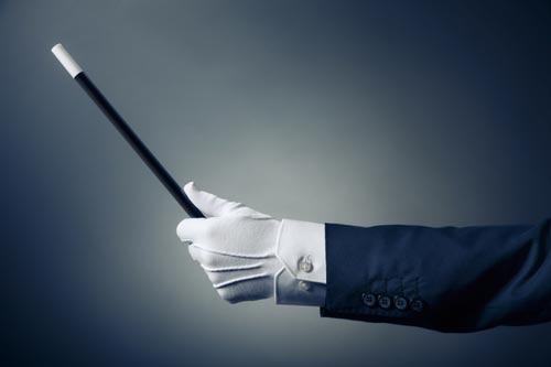 Magician's gloved hand holding a magic wand