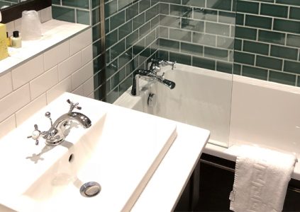A bath and sink in a bathroom at Parliament House Hotel