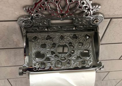 A detailed metal toilet roll holder in a bathroom at Parliament House Hotel