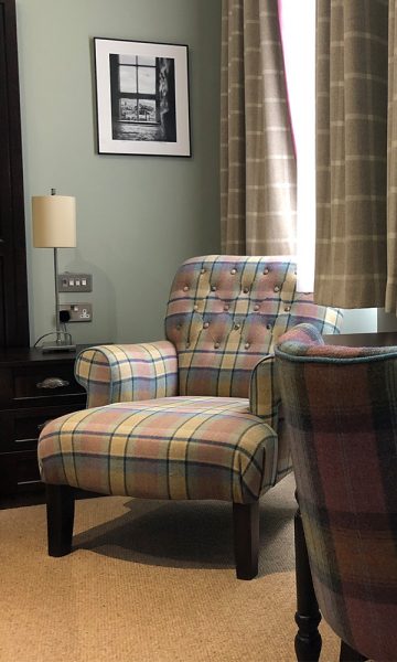 An armchair in a bedroom at Parliament House Hotel