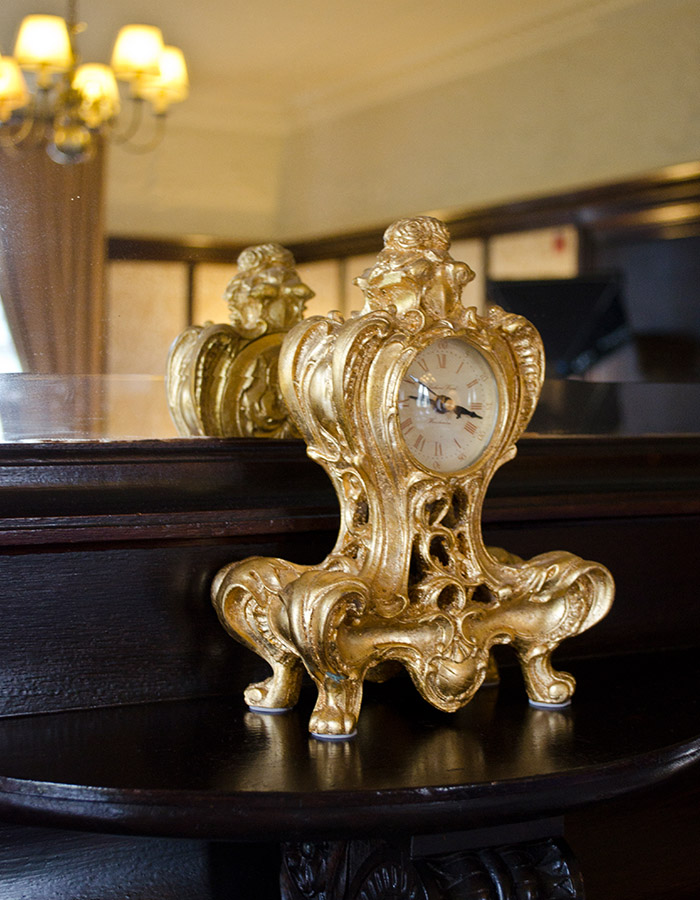 A gold ornamental clock on the mantelpiece in the Suite in Parliament House Hotel in Edinburgh