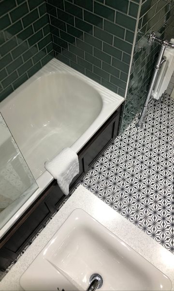 A bath, sink and patterned tiled floor in a bathroom in Parliament House Hotel in Edinburgh