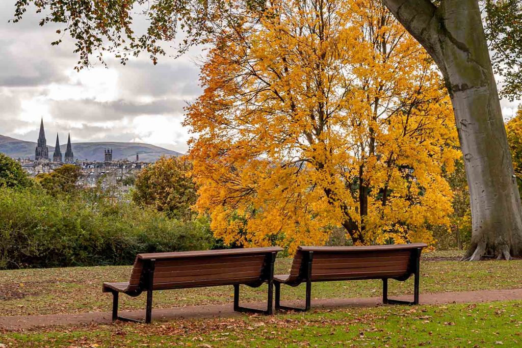 Two park benches in the Autumn overlooking Edinburgh City