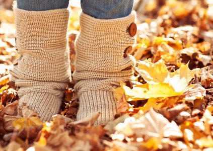 A person wearing knitted boots standing in Autumn Leaves