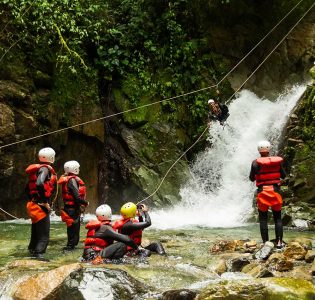 A group of people canyoning down a waterfall
