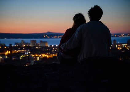 A silhouette of a couple over looking Leith in Edinburgh at night