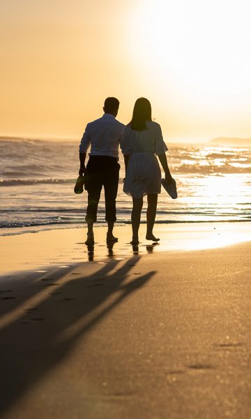 Couple walking along a sunset beach