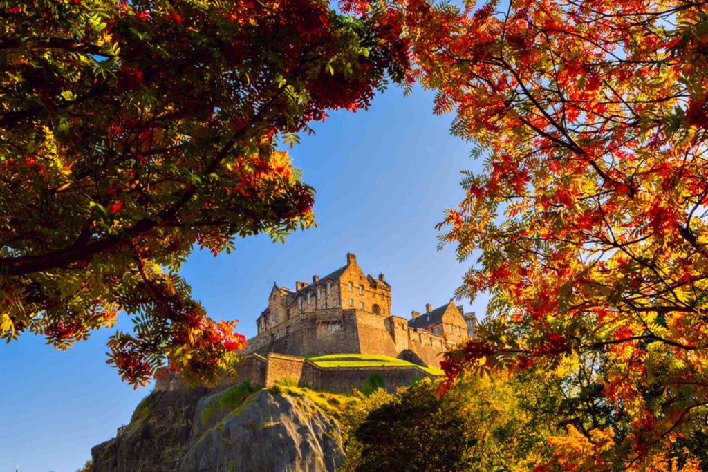 A view of Edinburgh Castle through trees of Autumn colour