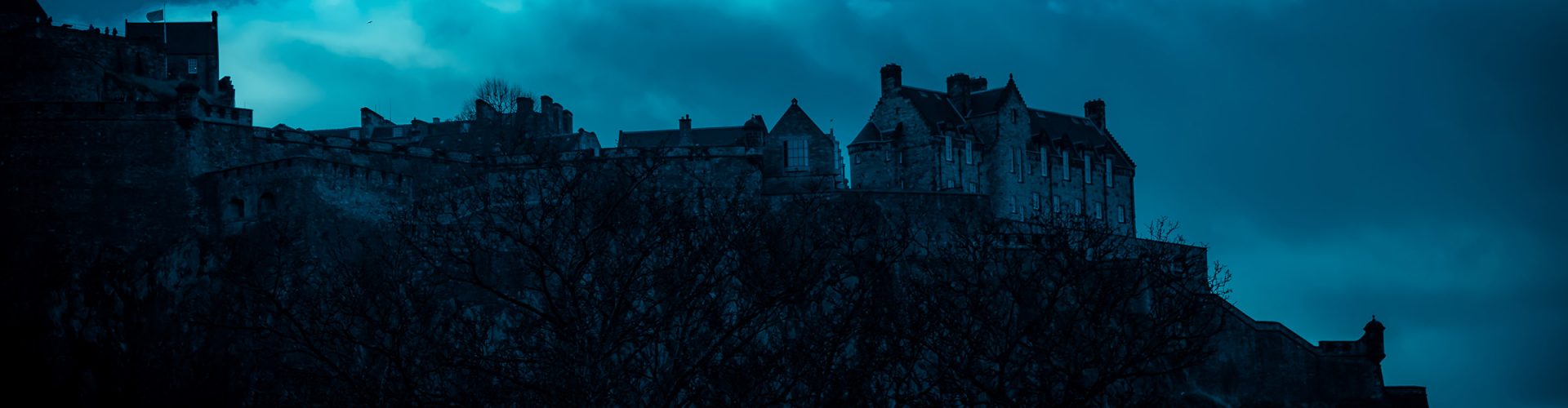 A spooky darkened silhouette of Edinburgh Castle at night