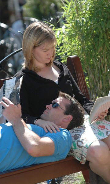 A couple reading on a bench in the sun at the Edinburgh International Book Festival