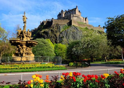 A view of Edinburgh Castle and Ross Fountain from Princes Street Gardens on a spring day