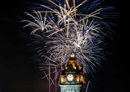 The clock on the Balmoral Hotel in Edinburgh with fireworks behind it