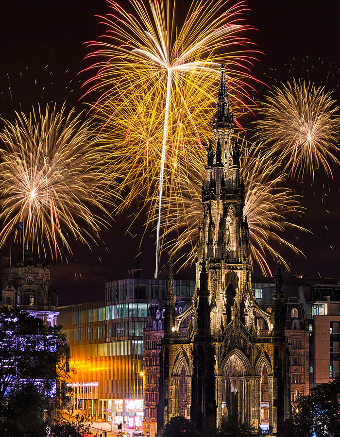 Ross Monument in Edinburgh with fireworks going off behind it