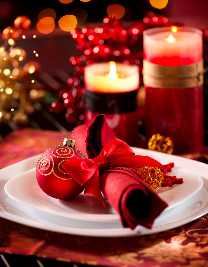 A table set for festive dinner celebrations with candles and baubles