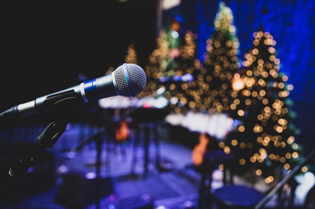 A microphone on stage with Christmas trees in the background