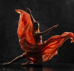 A ballet dancer with her orange dress floating out around her