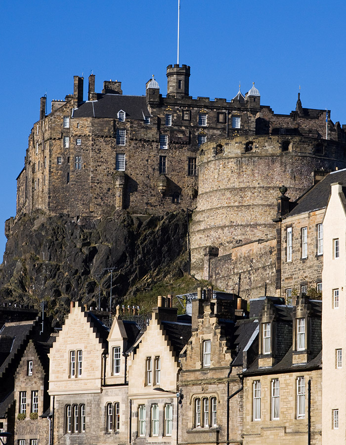 A view of Edinburgh Castle from The Grassmarket with blue skies