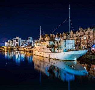 Leith Water lit up at night with boats docked on the still water