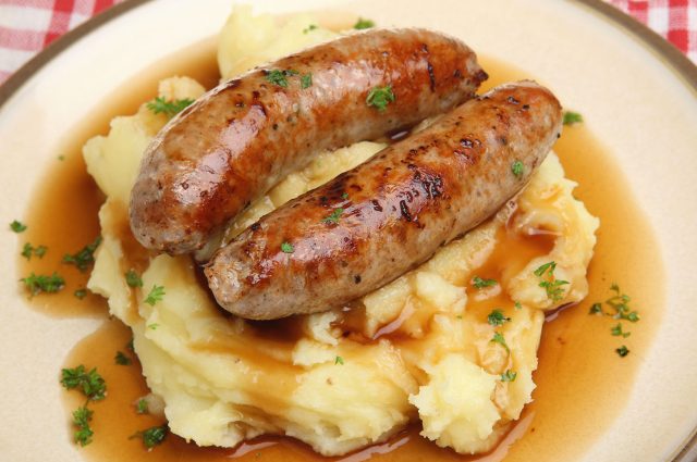 A plate of sausages and mash with gravy