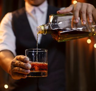 A bar man pouring a whisky