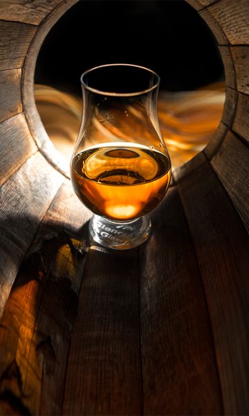 A glass of whisky in a barrel