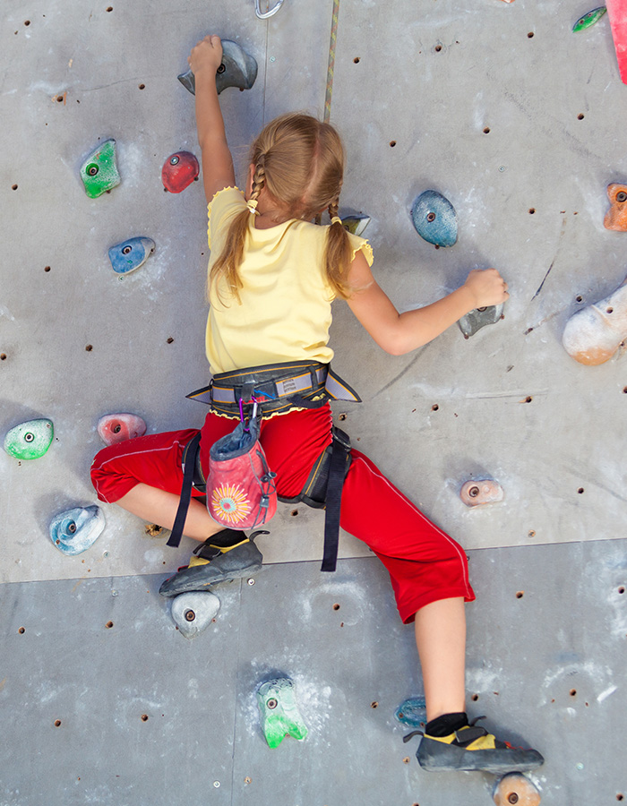A young girl on a climbing wall