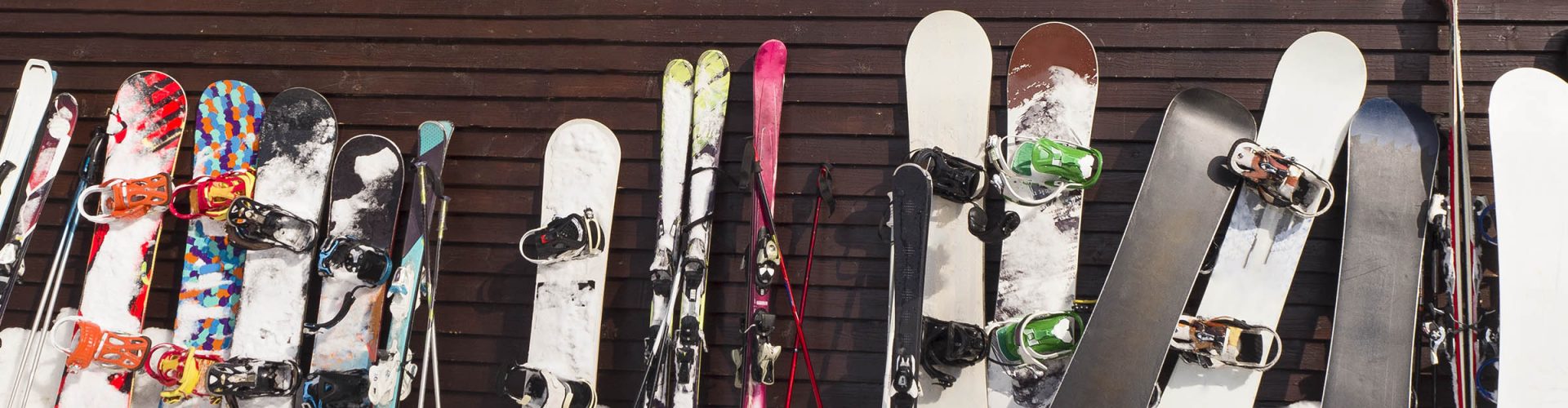 A row of skis and snowboards