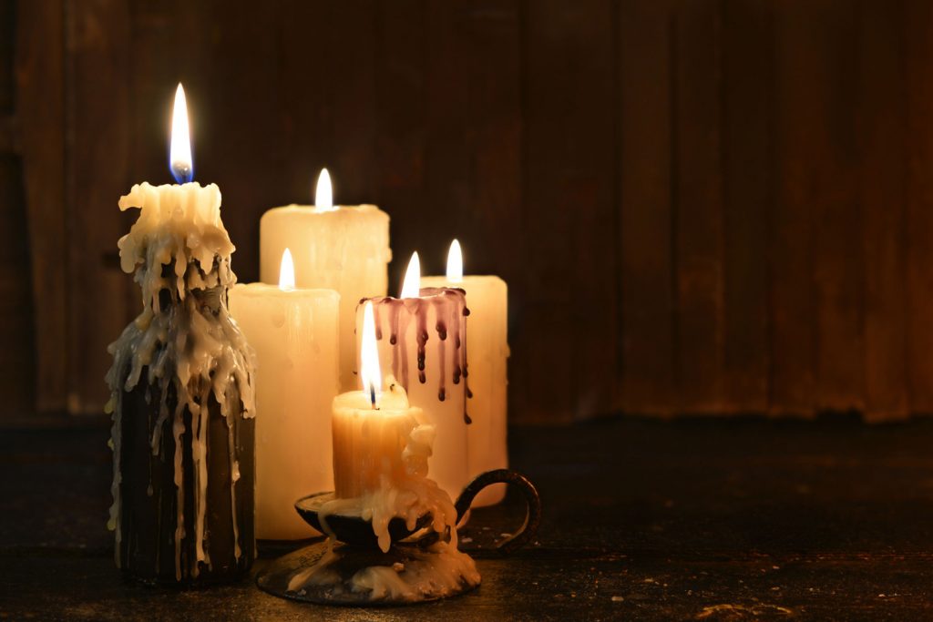 Candles dripping with wax in a dark room