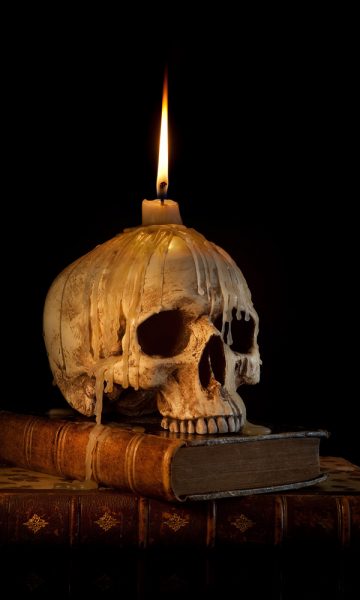 Skull candle and old books