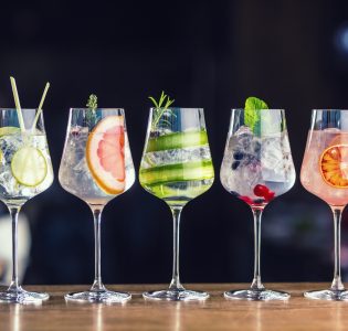 Five glasses of fruity gin cocktails side by side.