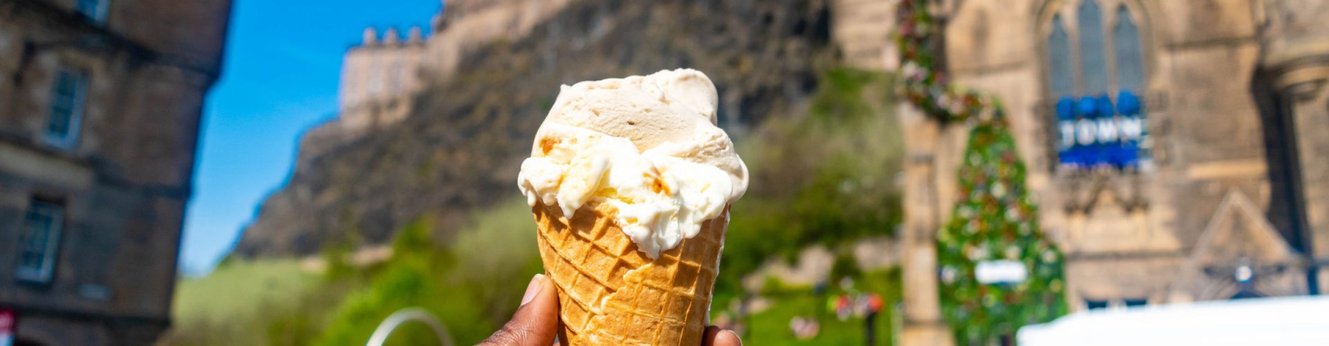Hand holding an ice cream on a sunny day in Edinburgh's Grassmarket