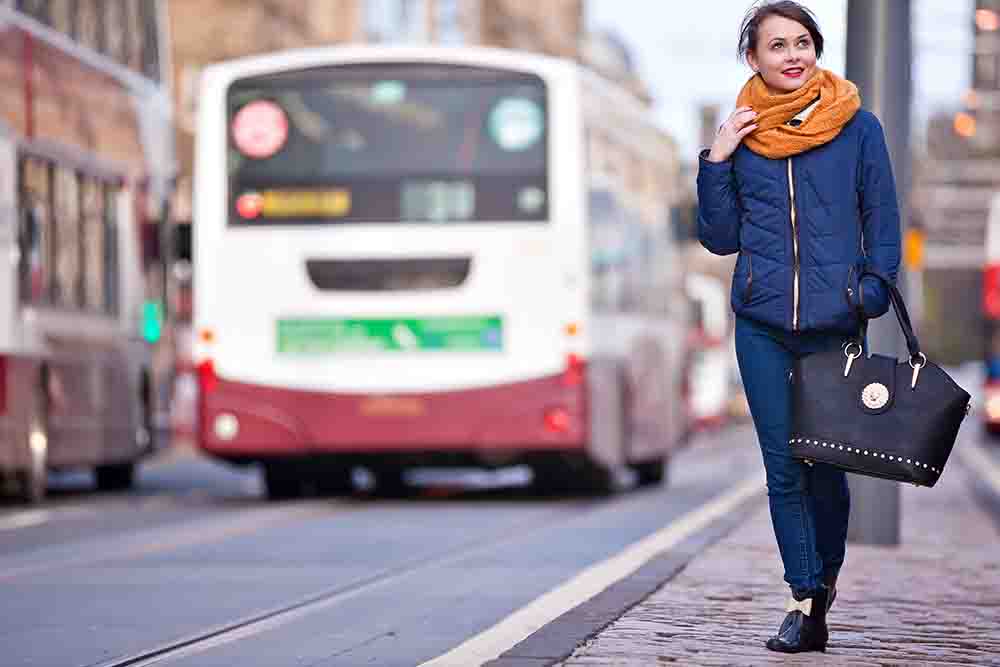 A woman alongside an Edinburgh bus.