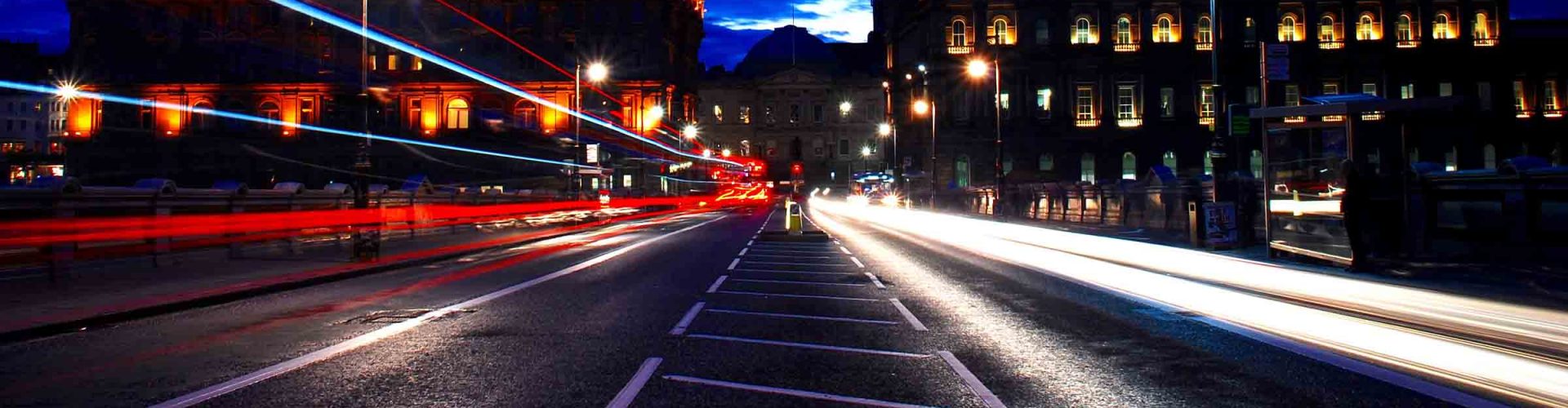 Edinburgh at night with lights from passing cars.